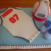 Baby Boy Shower Cake Shower cake for my baby cousin in 2007. His nursery was decorated in a sports theme. The onesie is fondant, on a buttercream iced cake. We...