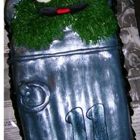 Oscar Oscar birthday cake. Garbage can is covered in grey fondant and painted over with sparkle dust. I used newspapser for the background to...
