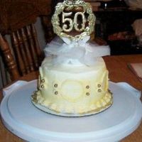 Close Up Of Topper 50Th Anniversary Cake close up of topper 50th anniversary cake. buttercream iceing dusted with shimmer gold dust.