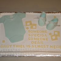 Baby Shower Baby shower cake. Almond sourcream poundcake with buttercream frosting.MMF onesie and gumpaste booties.