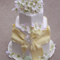 Spring Elegance Hexigon shaped cake with yellow fondant ribbon and non-edilbe flowers and pendant