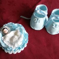Baby Booties And Baby In A Rose Sugar decorations for the tope of a baby shower or christening cake. Everything from gum paste.