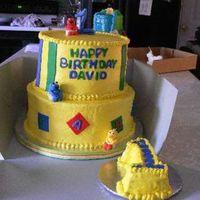 Baby Sesame Street Two tiered buttercream with fondant accents and fondant baby sesame street charactersThis was really fun!! oh and a #1 smash cake :)