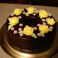 Chocolate Ganache Cake chocolate cake covered in dark chocolate ganache. Decorated with yellow roses we made in 1st Wilton Class.