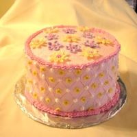 Gabby Cake View 2 WHITE ALMOND SOUR CREAM CAKE WITH BUTTERCREAM FROSTING AND FONDANT PEARLS AND FLOWERS. FILLED WITH STRAWBERRY MOUSSE.