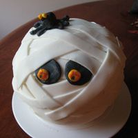 Friendly Mummy Chocolate cake using Sports Ball pan, BC icing, MMF for Mummy wrap, MMF eyes & spider. Just practicing for Halloween!