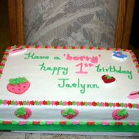Happy 1St Birthday Jaelynn! Cake is yellow marbeled with buttercream icing. Theme for the party was Strawberry Shortcake. A candle was placed on the cake at the party...