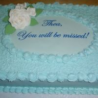 Thea's Retirement Gumpaste Rose and leaves. White Almond Sour Cream Cake with BC icing and filling. Cornelli Lace and wording is done on an edible image.