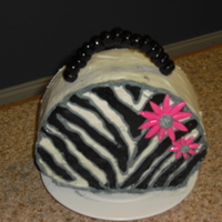 Zebra Purse Cake Frosted with buttercream; stripes are buttercream transfer, and flowers and handle are both marshmallow fondant.
