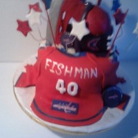 Washington Capitals Hockey Cake This sculpted cake has a hockey skate coming out of the middle of the cake with a Washington Captials Jersey laying on one side of the cake...