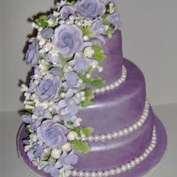 Lilac Wedding Cake Fondant covered 3 tier cake, hand painted in a custom lilac color to match bridesmaid dresses, Painted gumpaste Flowers, hand molded and...