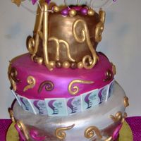 Fabulous 3 Tier Whimsical Cake Fondant covered and hand painted with sculpted ornaments. The Top tier has the persons name Angela going around the top made of fondant...