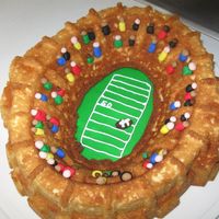 Football Stadium Used a stadium cake pan for this cake. I spread green icing under cake for field. People are made of fondant. I could have put more details...