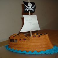 Pirate Ship Used a pirate ship cake pan, not much icing, didn't want to hide the details from the cake pan. Dowel rod with printout flags on...