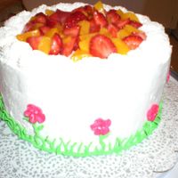 Birthday Cake angel food cake with whipped icing, strawberries and peaches in the middles and on top.