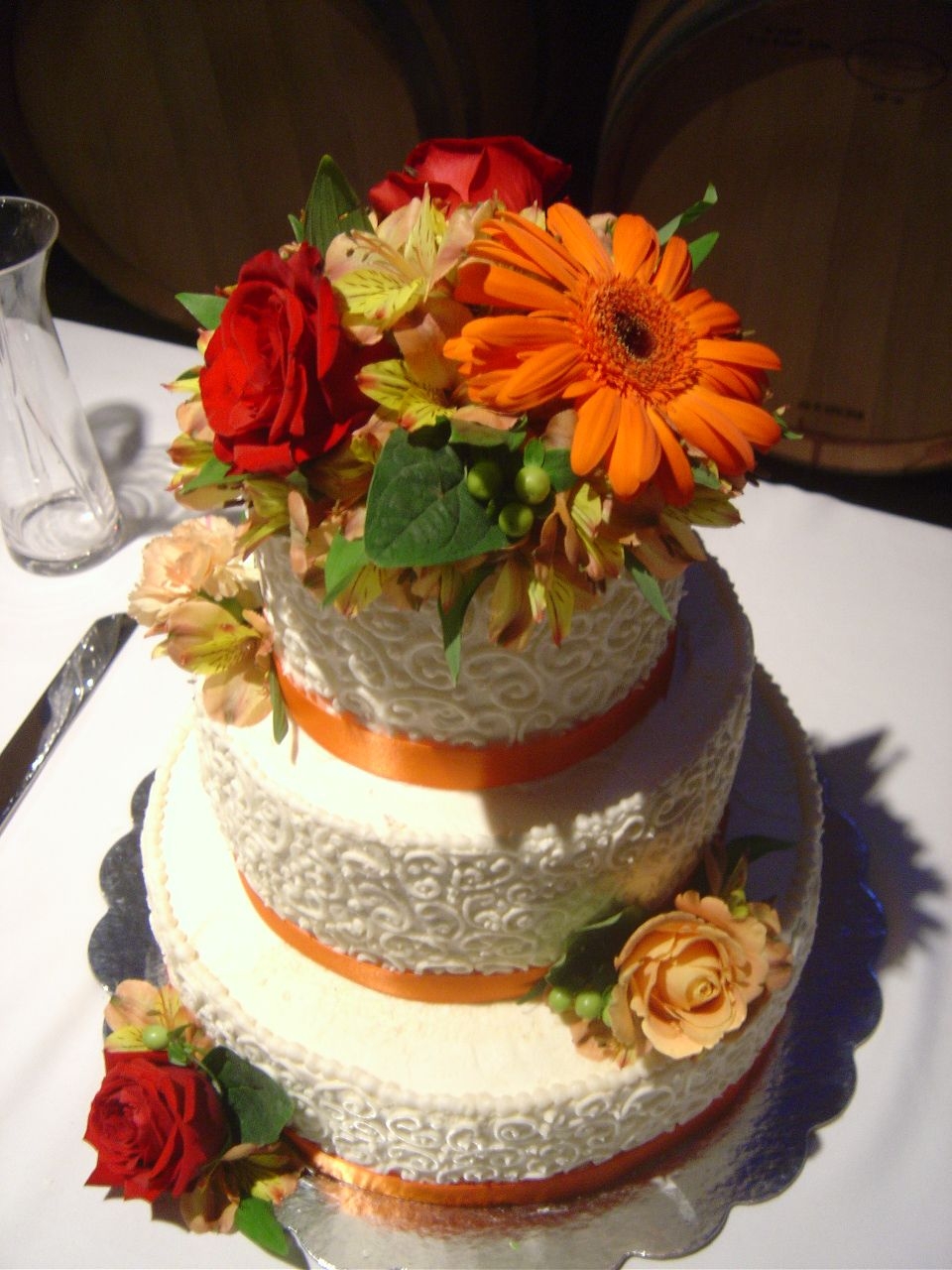 Beautiful Fall Wedding! Ivory buttercream frosting with orange ribbon and various flowers.