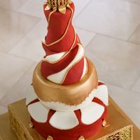 Gold Gate Wedding Cake Such a challenge and a dream cake! Gate on bottom tier is in piped RI. Surrounds a tier of cake. Top spire follows theme of gate in gold...