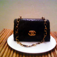 Classic Chanel Bag Cake A red velvet cake with buttercream icing. Covered in black fondant. Fondant gumpaste accents.