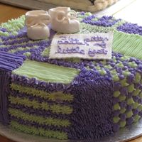 Baby's Quilt This was a cake I had done for a baby shower. The booties and banner are out of Fondant.