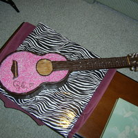 Taylor Swift Guitar Cake Brown "wood" is modeling chocolate. Strings are dental floss. Pink/silver bling is made with sugar crystals.