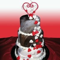 Cascading Hearts This cake is chocolate and white marbeled fondant. The hearts are fondant and the topper is gumpaste. Its chocolate and white cake in...