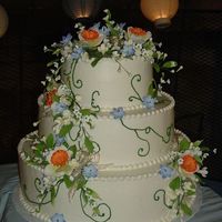 Round Stacked Wedding Cake With Sugar Paste Flowers (Tara's Cake) 16'-12"-8" round cake. All iced in buttercream. Moss green freely 'drawn' stem work. Sugar paste flowers cascade...