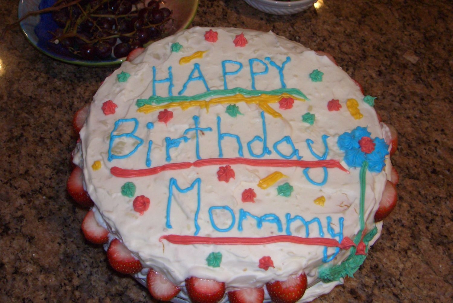 Mom's Birthday Cake anel food cake with strawbery filling. Whipped cream and lemon topping and decorated with white icing and strawberies.