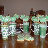 St. Patty's Day Cookie Bouquet Caramel sugar cookies with royal icing. The mugs are also filled with gold and silver nuggets.