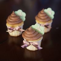 Baby Cupcakes Baby shower mini cupcakes. Chocolate buttercream frosting and filling, green fondant flower shaped toppers with buttercream V for the baby...