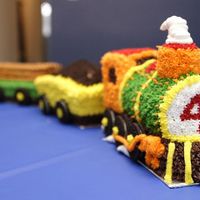 Engine Number 4 4 year old train cake with 4 cars. Engine made with Wilton 3D pan, caboose from carved pound cake, log and dirt cars made from loaf shaped...