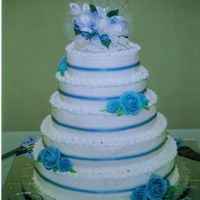 Blue Love My first wedding cake. 5 tiers, buttercream icing with blue royal icing roses. A blue sheer ribbon is in the middle of each tier. Each...