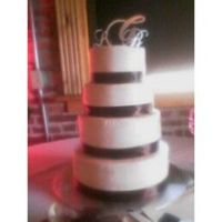 Satin Brown This was done recently for a friends wedding. A 4 tier buttercream, yellow/almond cake with a brown satin ribbon and platinum monograms.