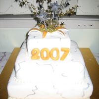 New Years Eve Fondant covered 3 tier stacked with fondant accents. I bought the streamers but the 2007 is fondant painted in gold.