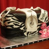 Brittany's Purse I cut a 9x13 cake in 3 and stacked. Covered in fondant. I painted on the zebra design and added fondant. and gumpaste like a coach purse I...