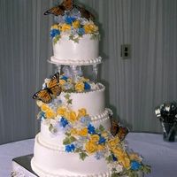 Butterfly Cake yellow gumpaste roses with blue accents. I cheated and used purchased butterflies Buttercream frosting with bead border.