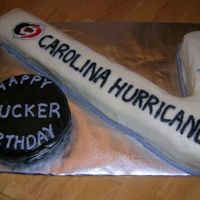 Carolina Hurricanes Hockey Stick And Puck White cake with BC icing and accents. Chocolate cake puck with chocolate icing dyed black. TFL