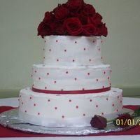 Round White With Red Dots This cake is a sour cream pound cake with buttercream frosting. It is white with red dots and rhinestones on each tier. The topper is a...