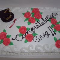 Graduation Cake CHOCOLATE CAKE WITH WHIPPED CREAM ICING AND BC DECORATIONS. WRITING IS NOT SO GOOD SORRY