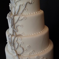 Silver & White 4-tier round cake with silver branches & white flowers with silver pearl centers. Very simple.