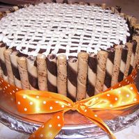 Triple Chocolate Decadence chocolate cake with a white chocolate cream filling, covered in chocolate ganache, and decorated with chocolate and vanilla piroulines, and...