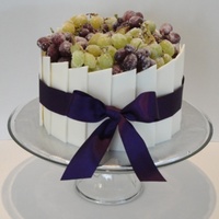 Chocolate And Sugared Grapes A regular buttercream cake covered in white chocolate panels (I hand cut each one) and topped with sugared grapes. Tied with a fabric...