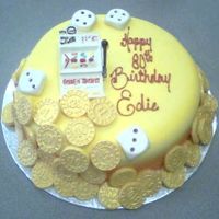 The Jackpot Fondant covered 10" cake, airbrushed in gold, white chocolate slot machine and yellow tinted white chocolate coins dusted with gold...