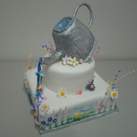 Watering The Flowers Cake was inspired by several cakes featured in the June 2010 Cake Central magazine. The cake was made for a fund raiser raffle at my niece...