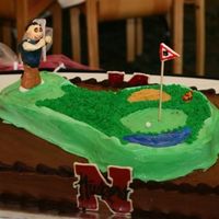 Golf, Bears, And Husker Fan Cake Choc. with Godiva chocolate BC. 11 by 14 with an inverted Dora pan for the golfing green. Figurine is fondant as is the snake (son in law...
