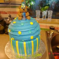Birthday Bear On A Large Cupcake This cake was for my nephews first birthday...chocolate cake, chocolate ganche and white cake w/ strawberry cheesecake filling. Iced in...