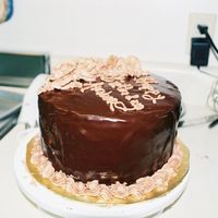 Chocolate Ganache Cake 8 in chocolate caked iced in choc bc, and covered in choc ganache. Decorated with choc bc roses.