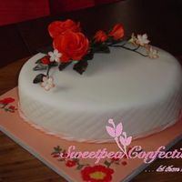 Orange Gumpaste Roses On Fondant Covered Oval Cake for a friend's retirement