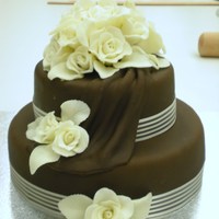 Chocolate Wedding Cake Chocolate mud cake with chocolate fondant covering & draping and white chocolate modeling paste roses. Made in class at Greensborough...