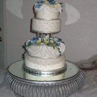 Terry This is a yellow cake covered in buttercream with fondant drapes, Pastille calla-lilies, and custom made acrylic pillars