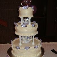 Stephanie's Wedding Cake Traditional white cake with buttercream frosting. Decorations were designed for the bride and made from purple fondant. The color and...